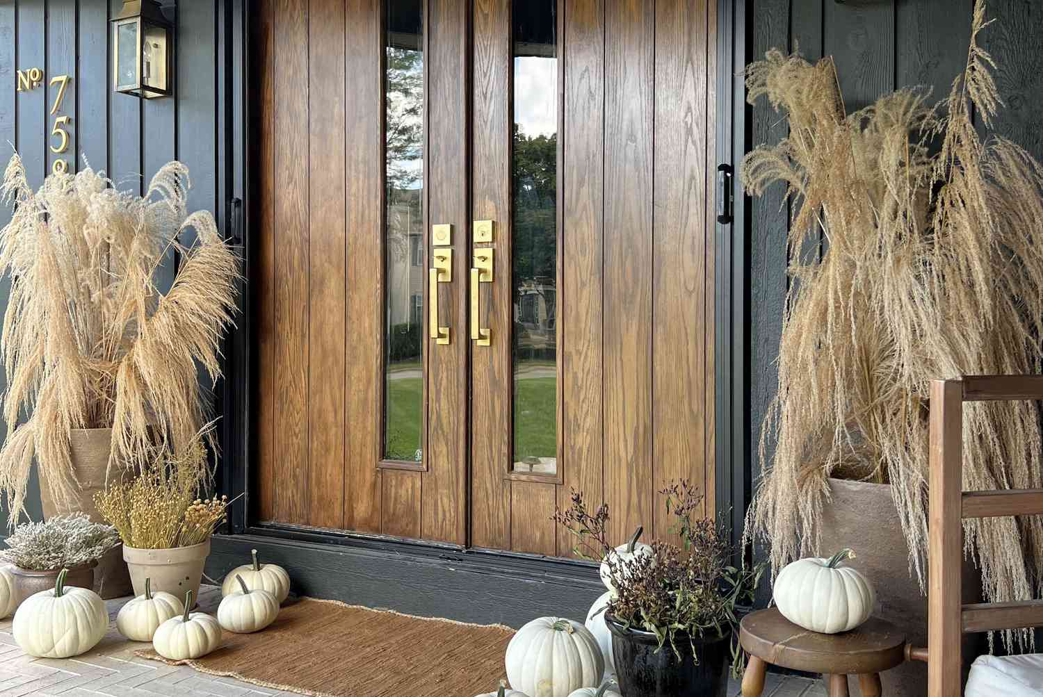 Neutral fall porch decor with white pumpkins, dried grasses, and modern farmhouse entryway