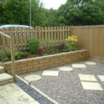 Low-cost wooden garden fence with raised flower bed and decorative backyard landscaping