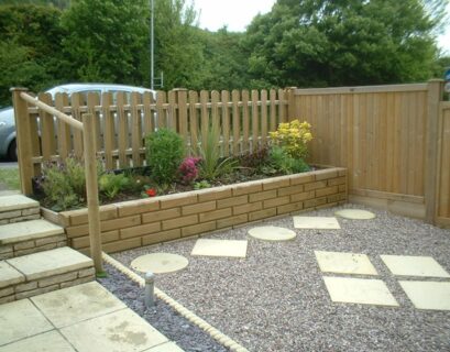 Low-cost wooden garden fence with raised flower bed and decorative backyard landscaping