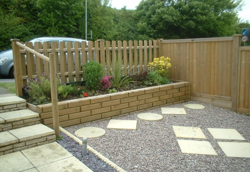 Low-cost wooden garden fence with raised flower bed and decorative backyard landscaping