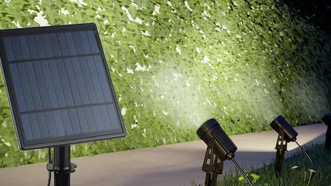 Solar powered LED spotlights illuminating plants at night with attached solar panel