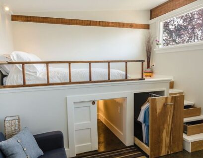 Tiny apartment loft bedroom with hidden storage under stairs and elevated sleeping area for small space living.