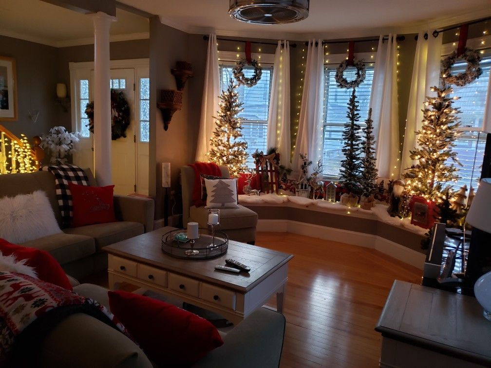 Stylish living room with cozy winter decorations, glowing Christmas trees, and warm January home decor accents.