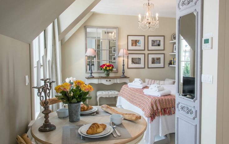 Cozy Parisian apartment bedroom with soft neutral decor, vintage accents, and elegant French-inspired styling.