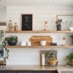 Bright kitchen with open shelf decor, white subway tiles, greenery, and wooden kitchen accessories.