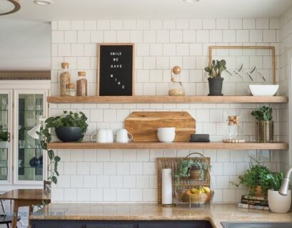Bright kitchen with open shelf decor, white subway tiles, greenery, and wooden kitchen accessories.