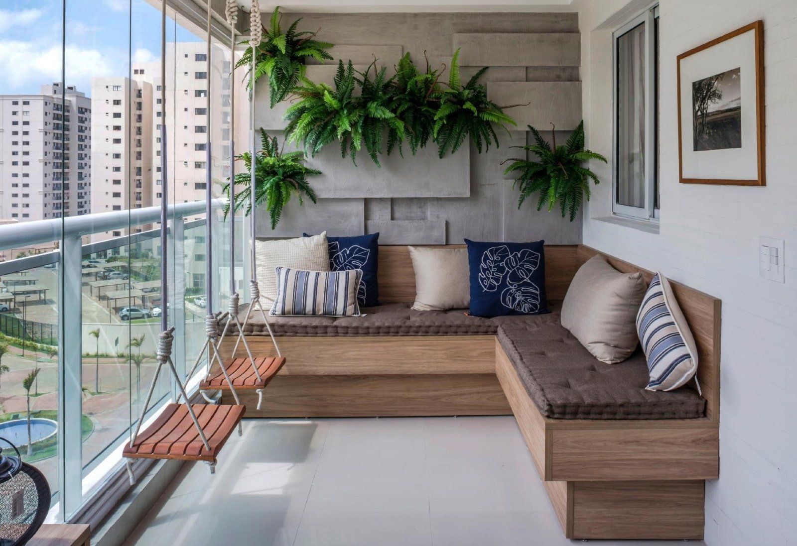 Compact apartment balcony with built-in wooden bench seating, hanging plants, and modern outdoor decor.