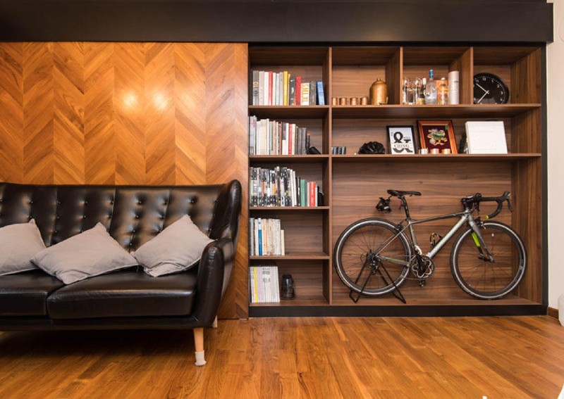 Industrial apartment organization setup with built-in bookshelves, bike storage, and modern loft-style decor.