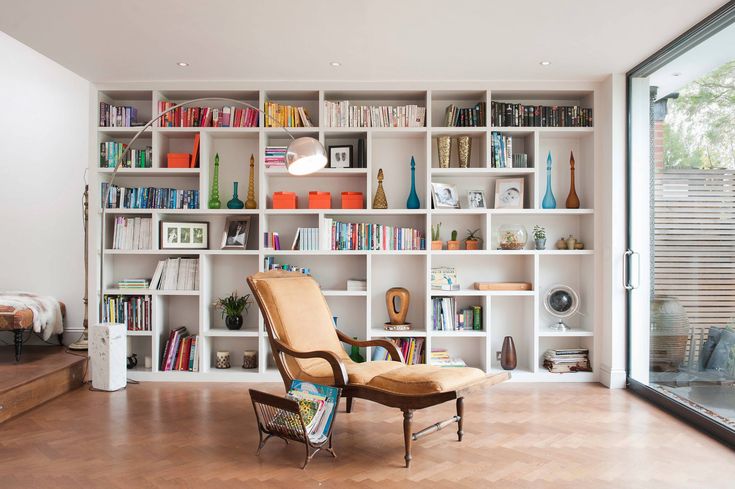 Large apartment wall bookshelf with organized storage, books, and minimalist modern interior styling.
