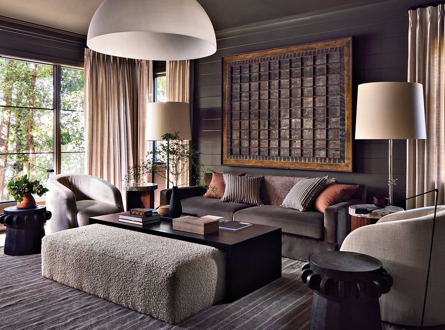 Moody living room with dark neutral colors, modern furniture, and cozy dramatic interior design