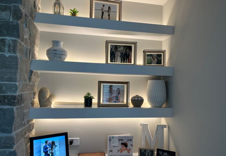 Modern floating wall shelves with LED lighting and decorative frames in a living room