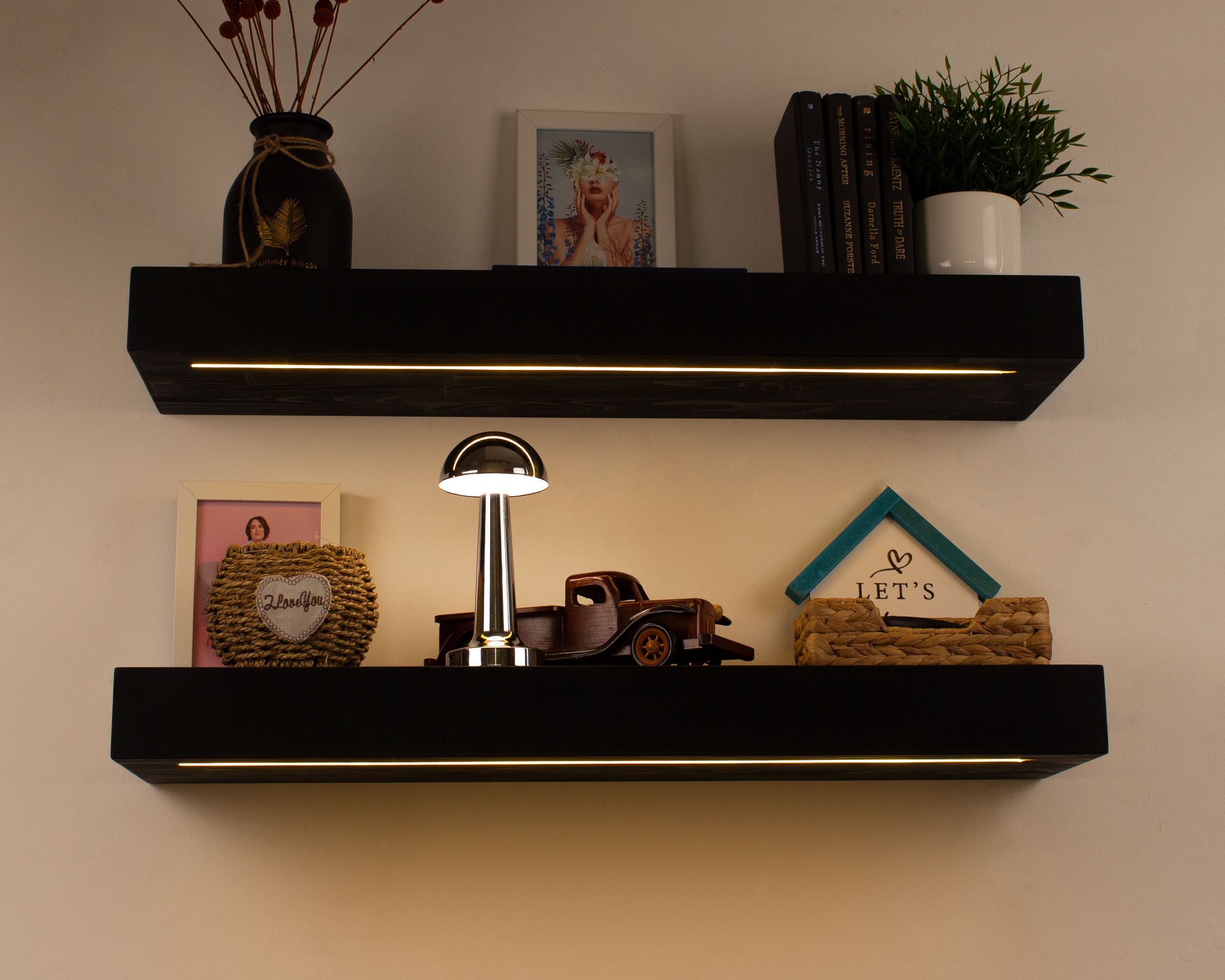 Black floating shelves decorated with books, plants, and modern home accessories