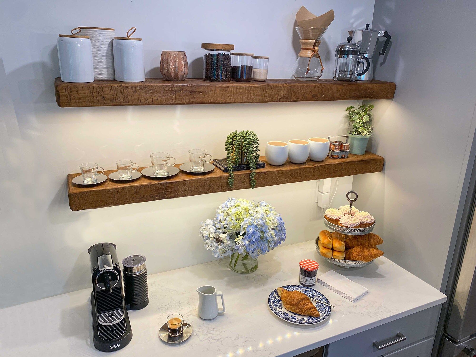 Kitchen floating shelves with mugs, plants, and stylish countertop decor