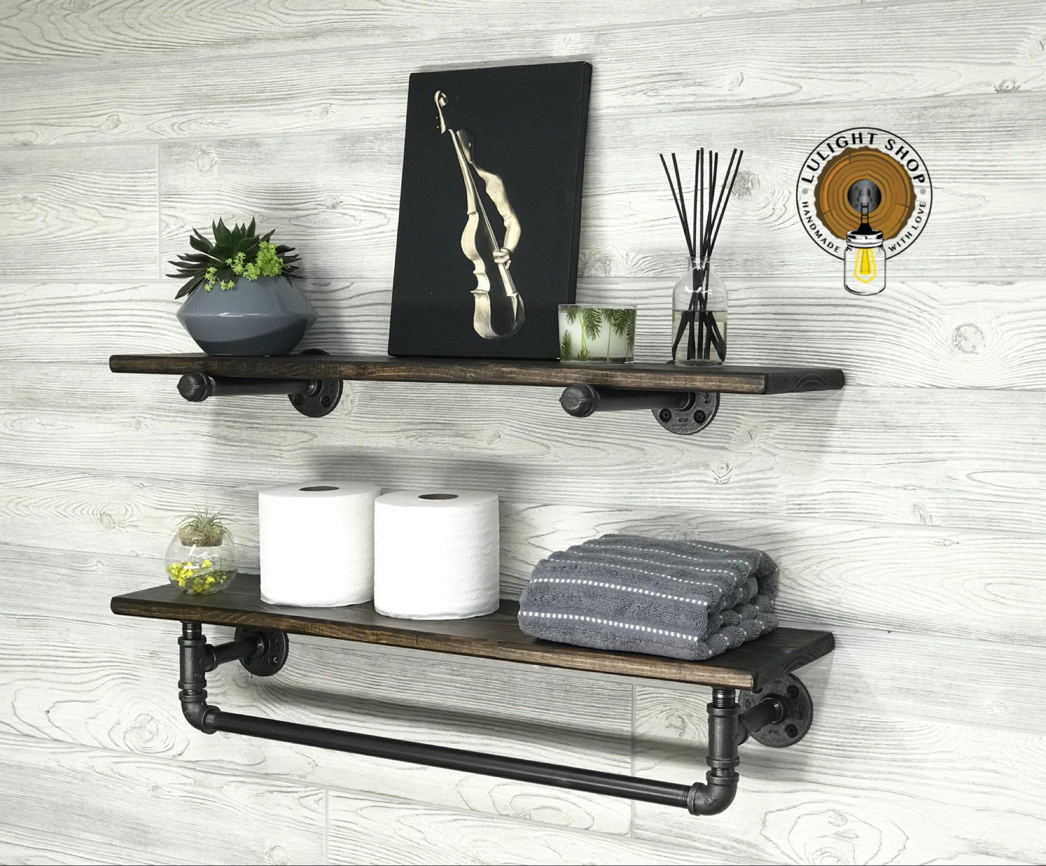 Modern bathroom shelf with towels, plants, candles, and black metal frame design